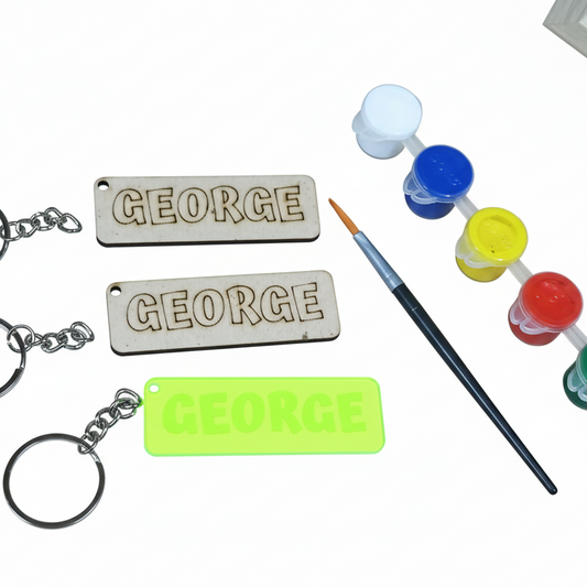 Personalized keychains and nameplates with painting supplies on a white background